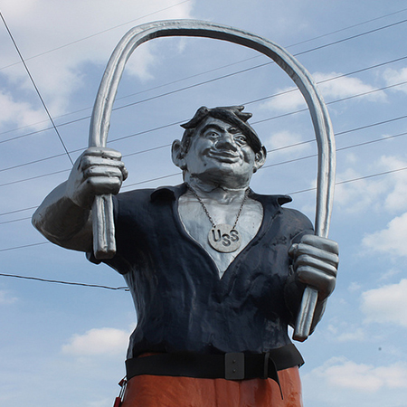 Statue of Joe Magarac bending a steel beam